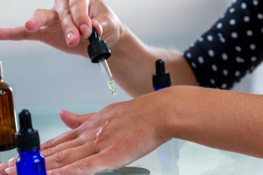 Yakın çekim pipeti eline bir damla yağ döküyor.