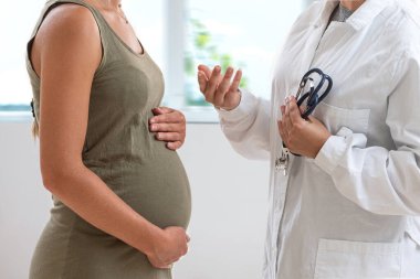 Doktor 7 aylık hamile hastasının önünde duruyor..