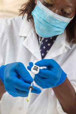 Doktor, kadın bir hastaya tam hormonal IUD vermeye hazır..