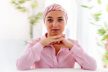 Önden hoş görünümlü, başörtüsü takan genç bir kadın.
