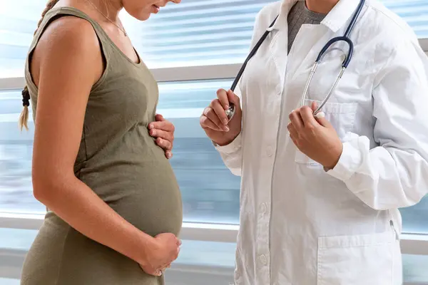 Lekarz Stojący Przed Pacjentem Siódmym Miesiącu Ciąży — Zdjęcie stockowe