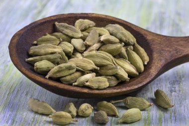 Ahşap arka planda kakule tohumları, yakın plan.