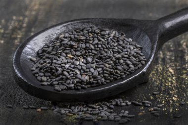 Ahşap arka planda siyah susam tohumları, yakın plan