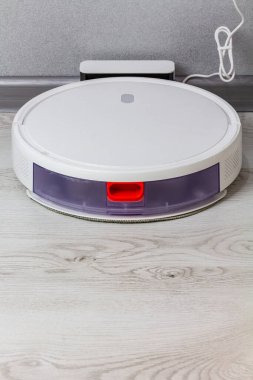 Robot elektrik süpürgesi şarj istasyonunda. Akıllı telefondan kontrol edilen akıllı teknoloji..