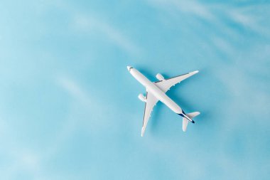 Mavi arka planda fotokopi alanı olan beyaz model bir uçak. Seyahat kavramı.