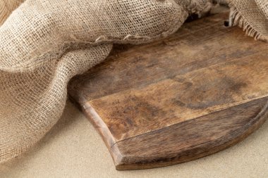 Tabak, yemek tarifi ya da metin için yeri olan boş ahşap bir tahta. Mutfak arka planı ahşap kesim tahtası ve fotokopi alanı olan jüt çuval..