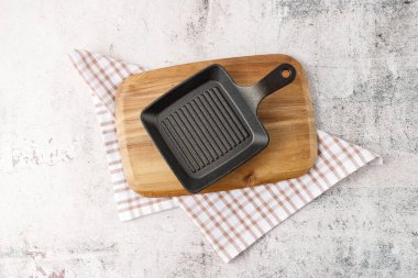 Mutfak havlusunun üzerine ahşap tahta tepsi boşalt. Retro taş masada et yemeği için yeri olan bir maket..