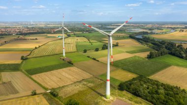 Tarlalardaki rüzgar türbinlerinin hava görüntüsü. Almanya 'da alternatif ekolojik yenilenebilir enerji üretimi. İklim kavramını değiştir. Drone fotoğrafçılık, doğa manzarası