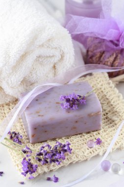 Aroma bitkisel el sanatları sabunu. Banyo için taze lavanta çiçekleri ve beyaz mermer masa arkaplanındaki sisal ağ torbasında vücut bakımı. Ev kaplıcası yaşam tarzı.