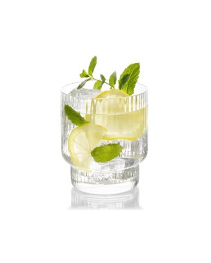 Limon dilimleri ve nane yapraklarıyla süslenmiş beyaz arka planda izole edilmiş şeritli camlarla soğuk içecek. Alkolik kokteyl ya da narenciye suyu bardakta içilir.