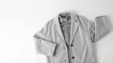 Tek renkli görünüm tarzında. Tarafsız kumaş arka planda açık gri yün ceket ya da ceket ve kaşmir süveter. Sonbahar kıyafeti. Moda.