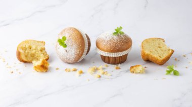 Taze pişmiş vanilyalı tarçınlı kek kremalı şeker tozu ve mermer masa arkasındaki kırıntılarla süslenmiş nane yaprağı tatlı tatlı olarak. Pastane ya da pastane afişi.