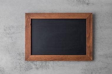 Boş eski siyah tahta ya da gri taş duvardaki okul karatahtası. Kopya alanı olan tahta koyu kahverengi karatahta.