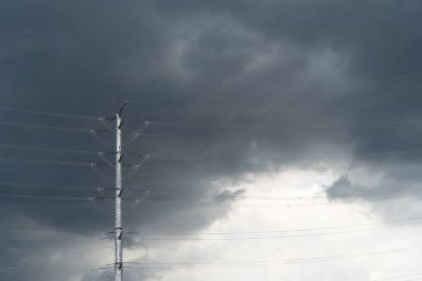 Scenic view of dark thunderstorm cloudscape over the high voltage tower.
