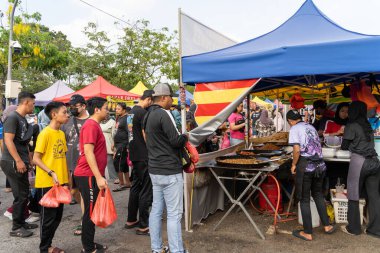 Kuala Lumpur, Malezya - 9 Nisan 2023: İnsanlar Ramazan Çarşısı çevresinde yiyecek ararken ve alırken görüldüler. Müslümanların kutsal Ramazan ayında oruç tutmaları sağlandı..