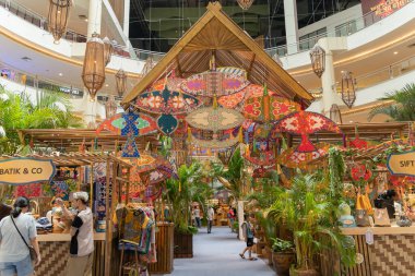 Kuala Lumpur,Malaysia - April 21,2023 : Traditional Colourful Malay Wau kites and decorations at the wau-themed kampung during Hari Raya at Mid Valley Megamall. People can be seen exploring around it. clipart