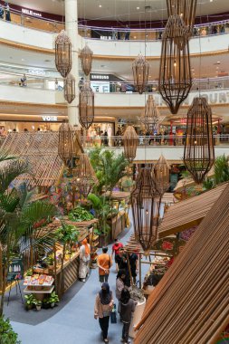 Kuala Lumpur, Malezya - 21 Nisan 2023: Geleneksel Renkli Malay Wau uçurtmaları ve Mid Valley Megamall 'daki Hari Raya sırasında vau temalı kampung süslemeleri. İnsanlar etrafı keşfederken görülebilir..