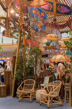 Kuala Lumpur, Malezya - 21 Nisan 2023: Geleneksel Renkli Malay Wau uçurtmaları ve Mid Valley Megamall 'daki Hari Raya sırasında vau temalı kampung süslemeleri. İnsanlar etrafı keşfederken görülebilir..