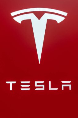 KL, Malezya - 3 Temmuz 2023: Tesla 'nın logosu ve markası kırmızı arkaplanda.