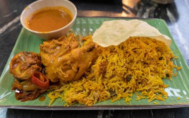 Close-up view of the biryani rice with curry chicken and papadam clipart