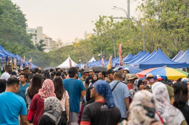 Kuala Lumpur, Malezya - 16 Mart 2024: İnsanlar Ramazan Çarşısı çevresinde yiyecek ararken ve satın alırken görüldüler. Müslümanların kutsal Ramazan ayında oruç tutmaları planlanıyor..