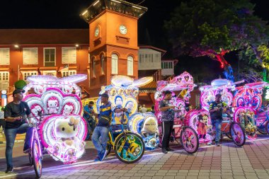 Malacca, Malezya - 20 Eylül 2024: Hollanda Meydanı 'nın önündeki renkli ışıklandırma parklarıyla süslenmiş bir sıra çekçek