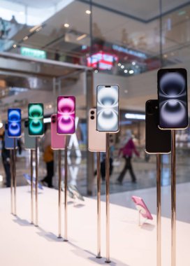 Kuala Lumpur, Malaysia - October 30, 2024 : Demo unit of the Iphone 16 displaying on the table at Apple Store. People can seen exploring around the store. clipart