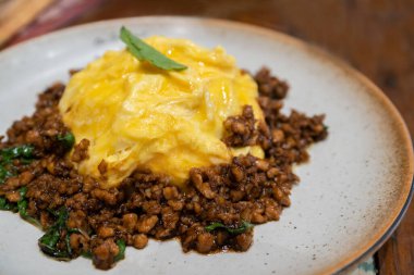 Kızarmış Tayland usulü kutsal fesleğen (Pad Kra Pao) yanında pirinçli kıyma ve sahanda yumurta..