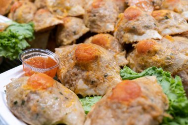 Yengeç kabukları içinde kırmızı biber soslu tavuk ve yengeç karışımı. Kabuklar lezzetli bir yengeç eti ve leziz tavuk karışımı ile doludur. Lezzetli ve benzersiz bir yemek oluşturur.