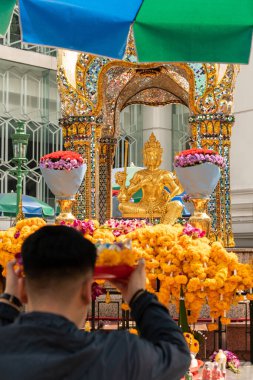Bir adam Bangkok, Tayland 'daki Erawan Tapınağı' nda dua ederken görülebilir..
