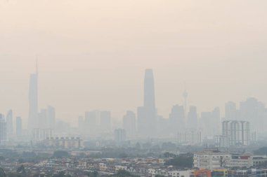 KL, Malezya - 22 Temmuz 2025: Kuala Lumpur şehri, muhtemelen hava kirliliğinden kaynaklanan sis veya sislerle gizlendi. Görüş mesafesi azaldı ve arka plandaki binalar solmuş ve bulanık görünüyor..
