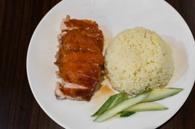 Tabakta taze salatalık dilimleriyle servis edilen lezzetli tavuklu pilavın üst görüntüsü..