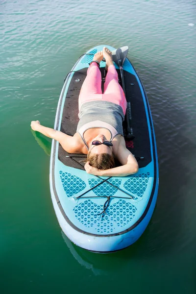 Supボードに横たわる若い魅力的な女性 リラックスして笑顔 — ストック写真