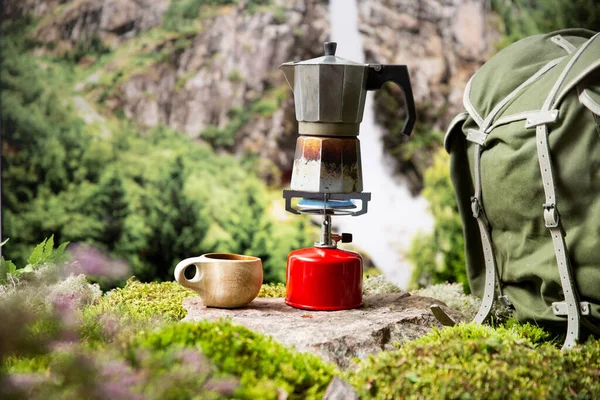 スカンジナビアの自然の背景を持つ赤いガスシリンダーでポータブルキャンプガスバーナーでコーヒーや紅茶を作る サマーハイキング エコツーリズム サバイバル — ストック写真