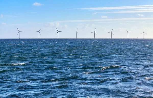 stock image Sea with a row of offshore wind turbines in distance on a sunny day.