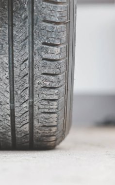 Güneşli bir günde, bir araba lastiğinin izine yaklaşıyoruz. Lastikler siyaha. Yakıt tasarruflu araba lastikleri.