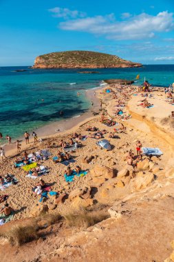 İbiza adasındaki Cala Comte plajında yüzüyor. Günbatımı için ideal bir sahil. Balearic