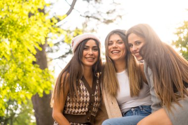 Sonbaharda bir parkta oturan kadın arkadaşlar, moda sonbahar yaşam tarzı, tasasız, heyecan, keyif