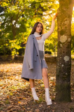 Gün batımında bir parkta sonbaharın keyfini çıkaran güzel bir kadının portresi.