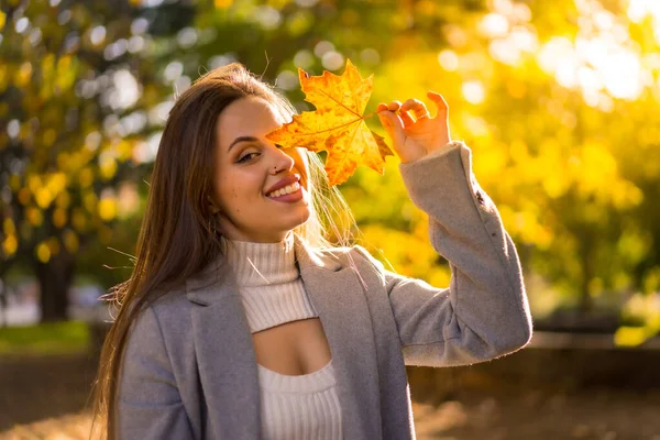 Μια Όμορφη Γυναίκα Απολαμβάνει Φθινόπωρο Ένα Πάρκο Ηλιοβασίλεμα Ένα Φύλλο — Φωτογραφία Αρχείου