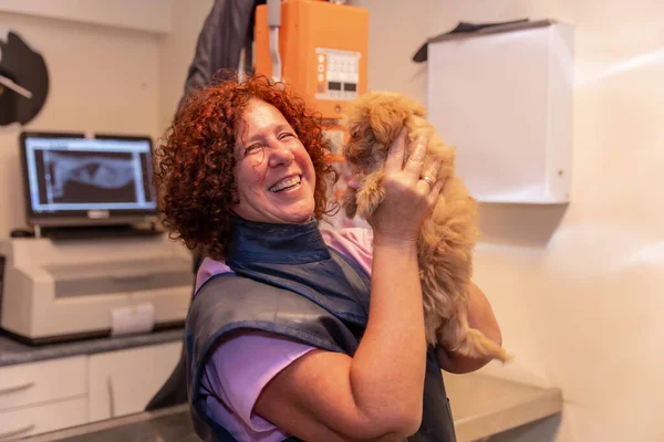 Veterinary clinic, portrait of veterinary owner with small dog smiling