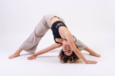 Stüdyoda genç bir dansçı, beyaz bir geçmişi var, bale, yerde büyük zorluklarla egzersiz yapıyor.