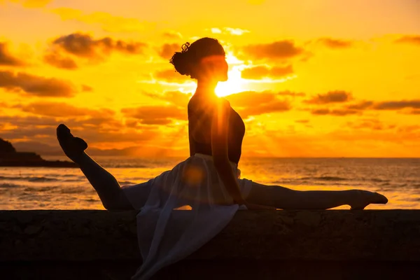 Μια Νεαρή Χορεύτρια Δίπλα Στην Παραλία Ηλιοβασίλεμα Κάνει Σπαγγάτα Θάλασσα — Φωτογραφία Αρχείου