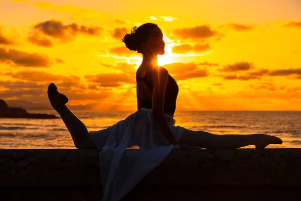 Μια Νεαρή Χορεύτρια Δίπλα Στην Παραλία Ηλιοβασίλεμα Κάνει Σπαγγάτα Θάλασσα — Φωτογραφία Αρχείου
