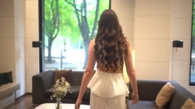 Beyaz bir parti elbisesi giymiş, yüksek topuklu ayakkabı giyen beyaz bir manken.