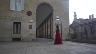 Beyaz bir parti elbisesi giymiş, yüksek topuklu ayakkabı giyen beyaz bir manken.