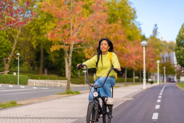 Young asian female student cycling on her way to university in europe, healthy life, eco friendly