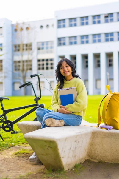 授業の合間に大学のキャンパスに座って笑っているアジア系女子学生 — ストック写真