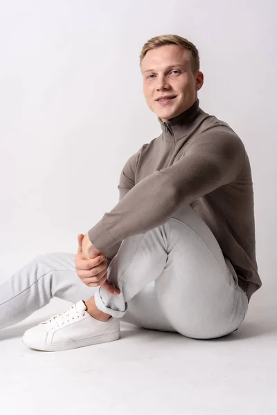 Blond Kaukasiska Modell Med Brun Tröja Vit Bakgrund Sitter Golvet — Stockfoto
