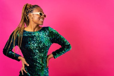 Pembe arka planda parti örgüleri olan Afrikalı genç bir kadın. Stüdyo dansı.